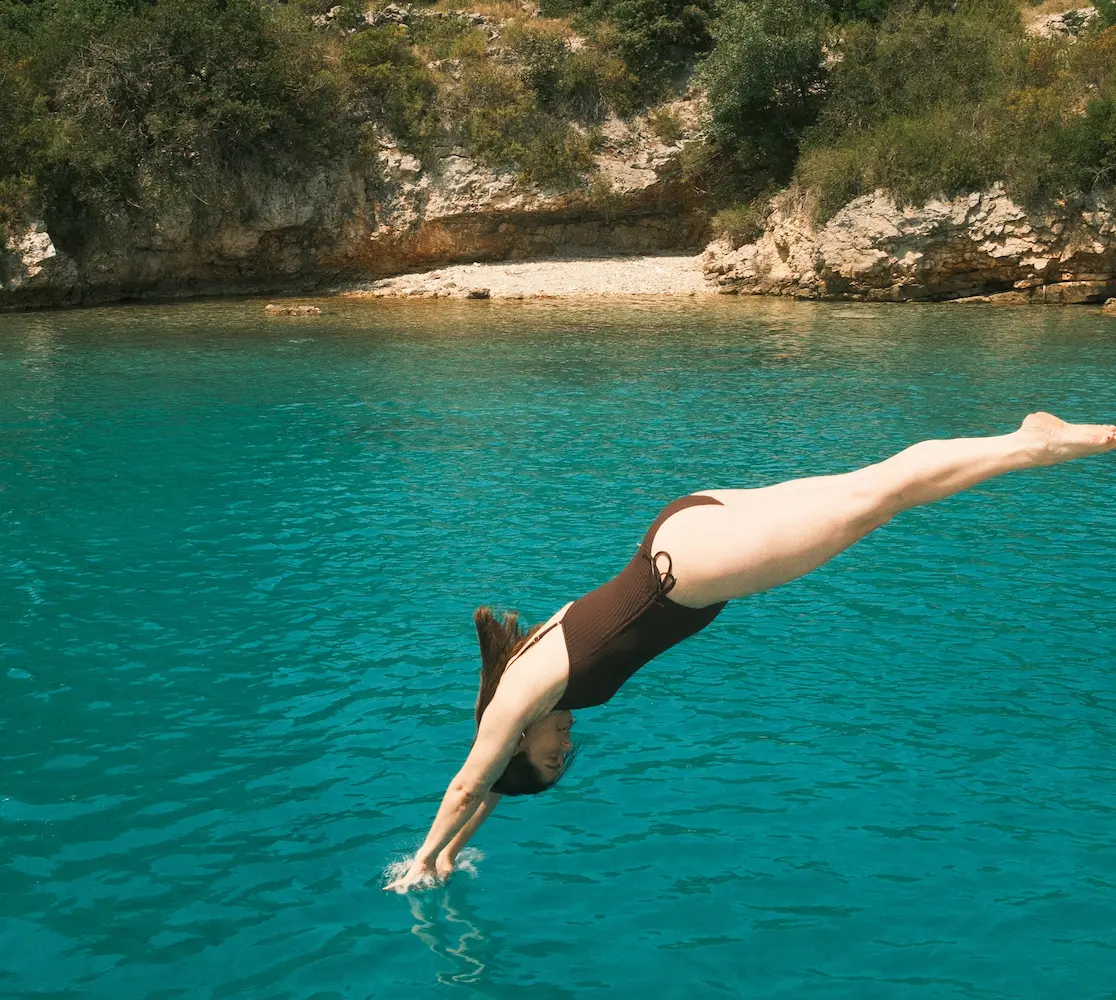 woman diving off side of boat
